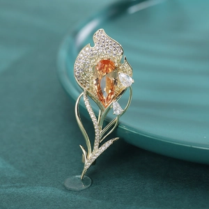 Détail d'une broche tulipe dorée avec pierre poire orange et zircons micro-sertis