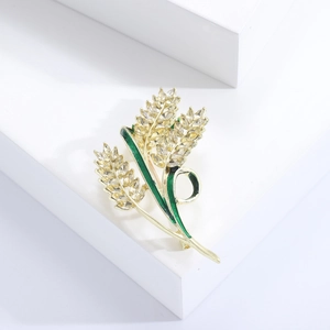 Dettaglio della spilla a spiga di grano con strass scintillanti e foglie in smalto verde