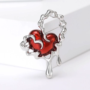 Detail view of the silver liquid metal melting design around a red enamel heart brooch