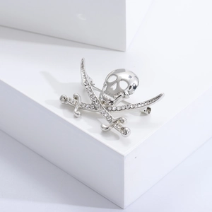 Detailed close-up of pirate skull and crossed cutlasses brooch with crystal insets
