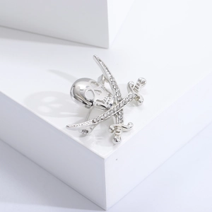 Macro shot of silver pirate skull and crossed cutlasses brooch with rhinestone details