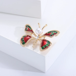 Détail d'une broche papillon vintage avec ailes en émail rouge et strass brillants