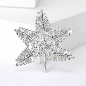 Detailed macro shot of a baroque maple leaf brooch with sparkling baguette-cut crystals