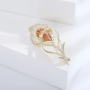Détail d'une broche tulipe dorée avec zircon ambre et micro-pavé de diamants fins