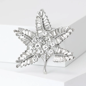 Macro view of silver maple leaf brooch featuring intricate baguette-cut crystal stones