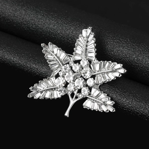 Macro detail of leaf brooch featuring silver plating and rectangular crystal inlays