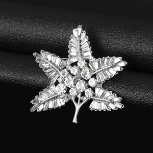 Macro shot of maple leaf brooch featuring crystal rhinestones and silver alloy base