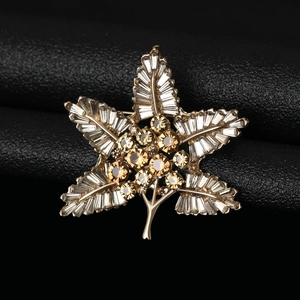 Macro shot of Baroque leaf brooch with gold alloy, clear zircons and amber crystals
