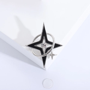 Detailed view of silver star brooch with black enamel and a central zircon stone