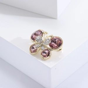 Détail de la broche papillon dorée avec gemmes roses facettées et cristaux brillants