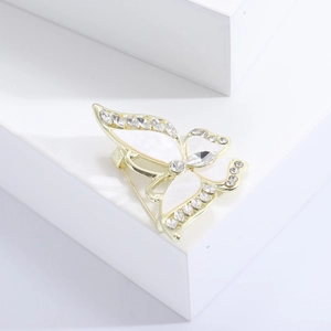Elegante broche de mariposa dorado con alas de nácar blanco y cristales brillantes