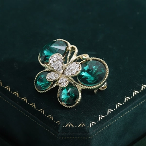 Broche papillon vintage dorée avec pierres précieuses vert émeraude et cristaux brillants