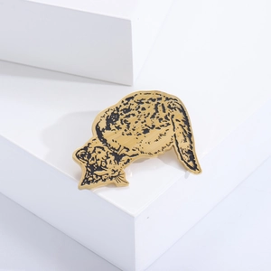 Detailed close-up of a golden leopard brooch with black enamel spots on a white prop
