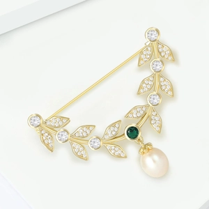 Elegant gold leaf brooch with green gemstone and white teardrop pearl pendant