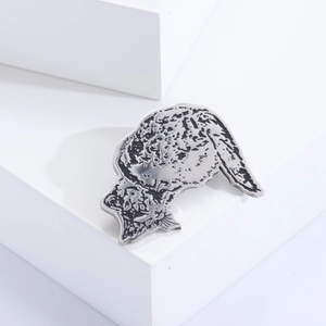 Detailed macro view of a vintage silver cat brooch with engraved fur texture details