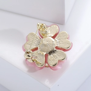 Detailed view of the flower brooch back with golden metal base and secure pin clasp