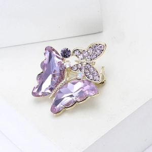 Detail of luxury butterfly brooch with purple crystals and gold alloy plating