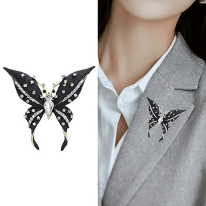 Elegant butterfly brooch with black wings and crystal rhinestones on a blazer lapel