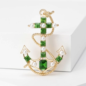 Vintage gold anchor brooch with green emerald-cut gemstones and elegant white pearls