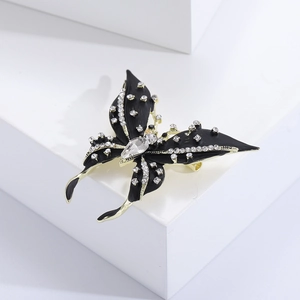 Detail of black enamel butterfly brooch with gold plating and sparkling white crystals