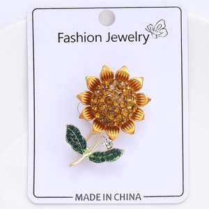 Detailed macro view of enamel sunflower brooch with vibrant yellow and green crystals