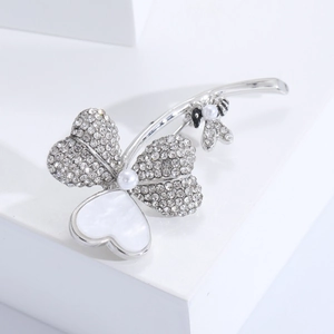Détail de la broche trèfle argentée avec nacre, strass et petite abeille en perle