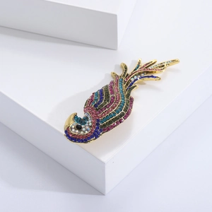 Detailed close-up of a golden parrot brooch with colorful rhinestones on white blocks