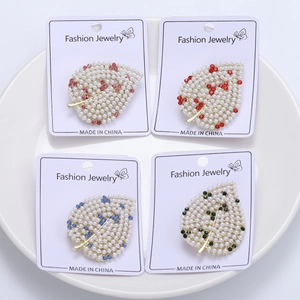 Lot de 4 broches feuilles tendance avec strass colorés et perles sur carte de vente
