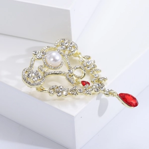 Detail einer Vintage Barock-Brosche mit Goldlegierung und rotem Tropfen-Edelstein