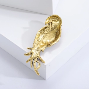 Detailed back view of parrot brooch featuring golden alloy texture and safety pin buckle