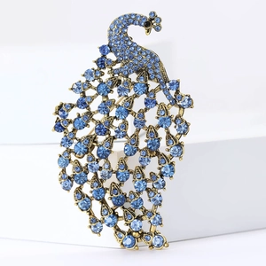 Detail of vintage peacock brooch with blue rhinestones on golden metal base