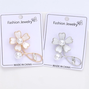 Detail of shell flower brooches with faux pearls and rhinestones on jewelry cards