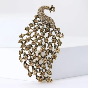 Detailed close-up of a vintage gold peacock brooch with sparkling champagne rhinestones