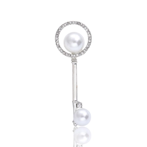Elegant silver key brooch with white pearls and sparkling crystals on white background