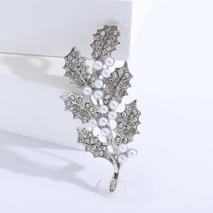 Détail de la broche feuille ornée de strass clairs et perles blanches sur placage d'argent