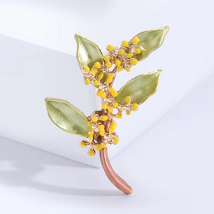 Elegante spilla di osmanto dorata con foglie di smalto verde e fiori gialli