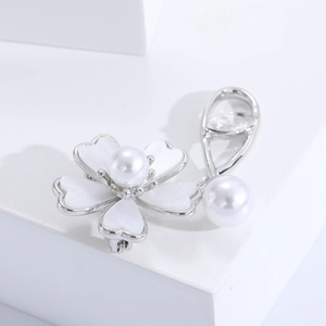 Macro detail of elegant white floral brooch with pearls and shimmering rhinestones