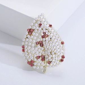 Détail de la broche feuille avec perles blanches et strass roses sur alliage doré