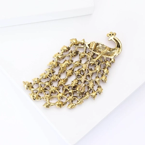 Detailed back view of vintage gold peacock brooch showing hollow mesh and pin fastener
