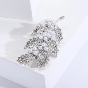 Détail de la broche en feuille d'argent avec strass brillants et perles blanches