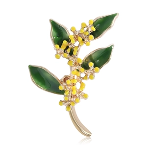 Elegante spilla a forma di osmanto dorato con foglie in smalto verde e fiori gialli