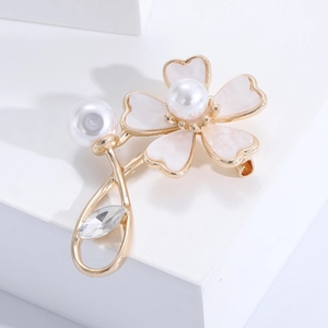 Macro view of floral brooch with shell petals, pearl center and clear rhinestone detail
