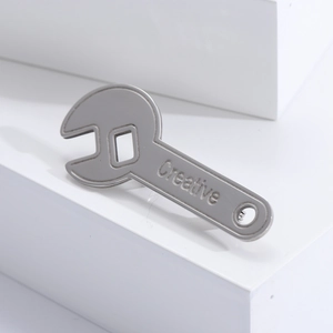 Macro detail of silver stainless steel wrench brooch with Creative engraving on the handle