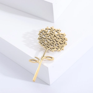 Gros plan d'une broche pissenlit dorée avec texture métallique mate et détails de feuilles