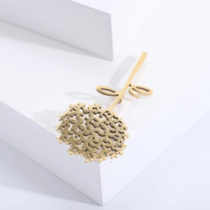 Broche fleur de pissenlit dorée en acier inoxydable sur un support géométrique épuré