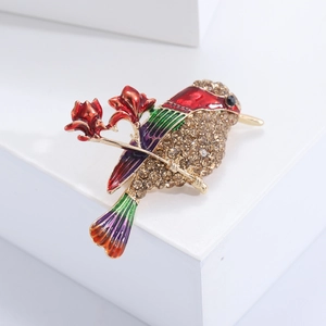 Détail d'une broche oiseau en émail avec ailes colorées et strass couleur champagne