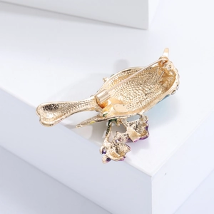 Détail du dos doré de la broche oiseau en alliage avec un fermoir rotatif de sécurité