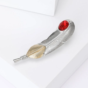 Minimalist feather brooch with red gemstone in silver and gold metal finish