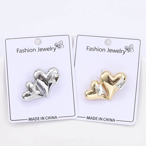 Gros plan de boucles d'oreilles cœur en or et argent avec cristaux rectangulaires