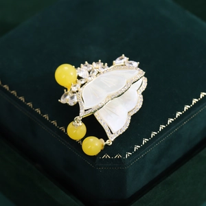 Detailed macro shot of vintage butterfly brooch with mother of pearl and gold finish